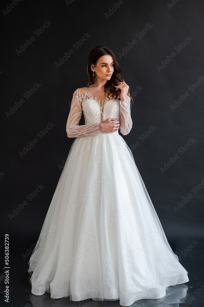 Beautiful bride in a magnificent white wedding dress of tulle with corset lacing and long beauty hair Beautiful bride in a magnificent white wedding dress of tulle with corset lacing and long beauty hair