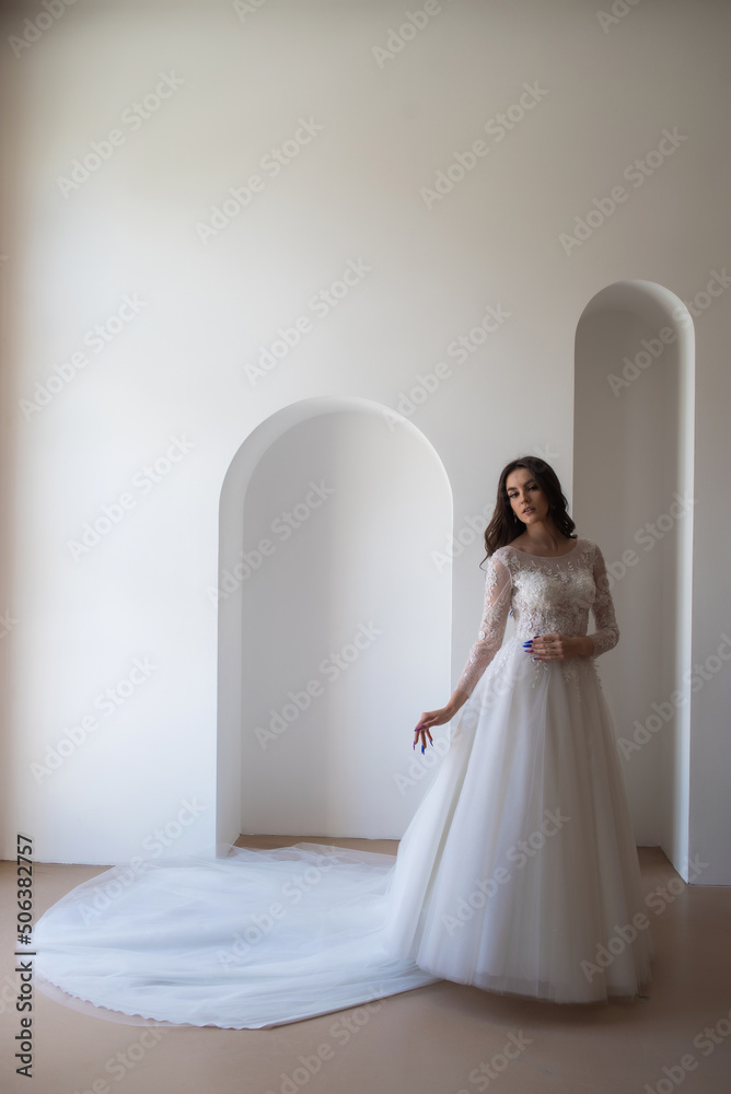 Full length portrait of young beautiful woman wearing white wedding dress. Elegant bride standing and posing Full length portrait of young beautiful woman wearing white wedding dress. Elegant bride standing and posing