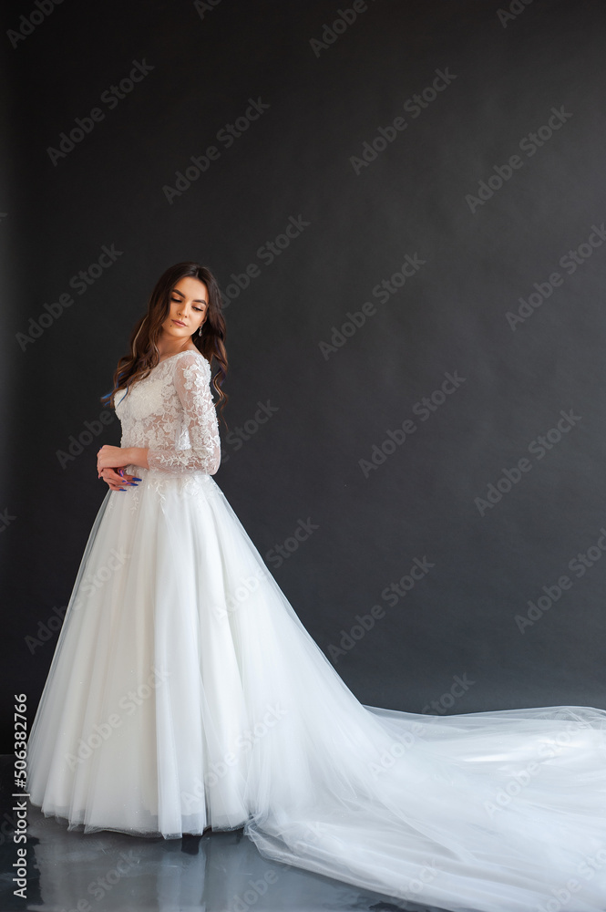 Full length portrait of young beautiful woman wearing white wedding dress. Elegant bride standing and posing Full length portrait of young beautiful woman wearing white wedding dress. Elegant bride standing and posing