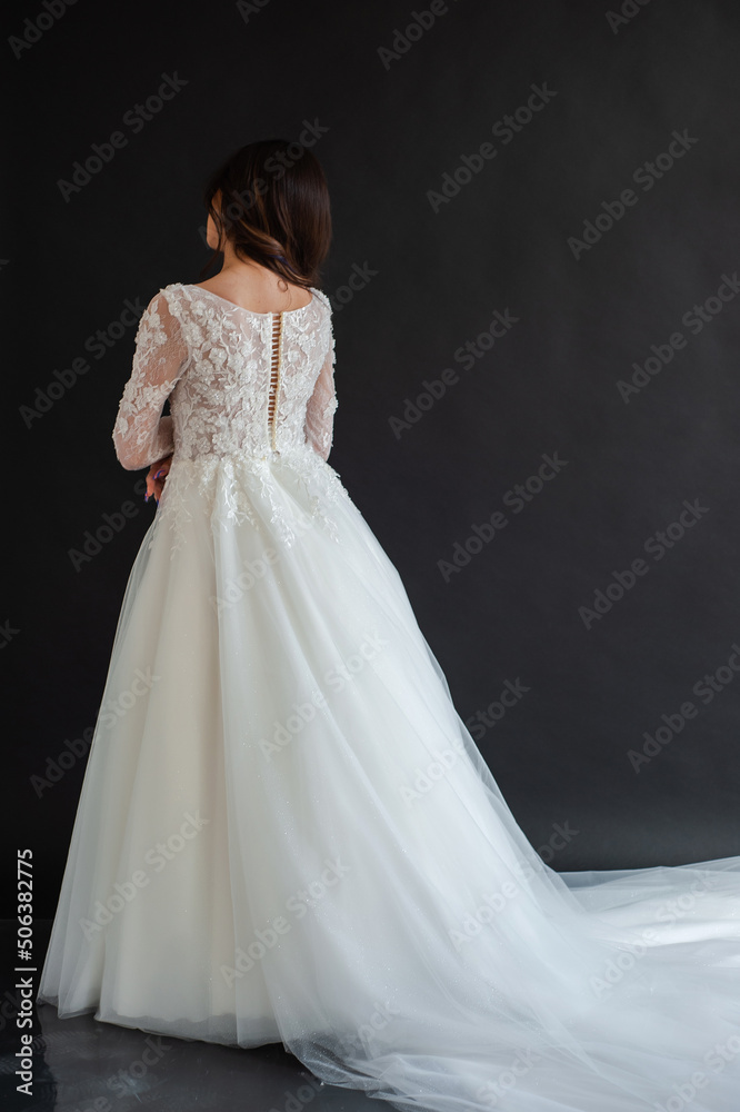 Full length portrait of young beautiful woman wearing white wedding dress. Elegant bride standing and posing Full length portrait of young beautiful woman wearing white wedding dress. Elegant bride standing and posing