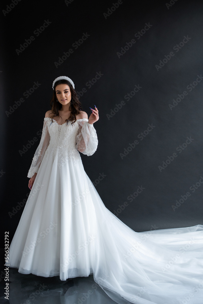 Full length portrait of young beautiful woman wearing white wedding dress. Elegant bride standing and posing Full length portrait of young beautiful woman wearing white wedding dress. Elegant bride standing and posing