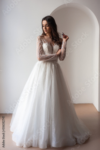 Beautiful bride in a magnificent white wedding dress of tulle with corset lacing and long beauty hair