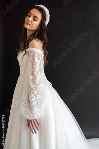 Full length portrait of young beautiful woman wearing white wedding dress. Elegant bride standing and posing