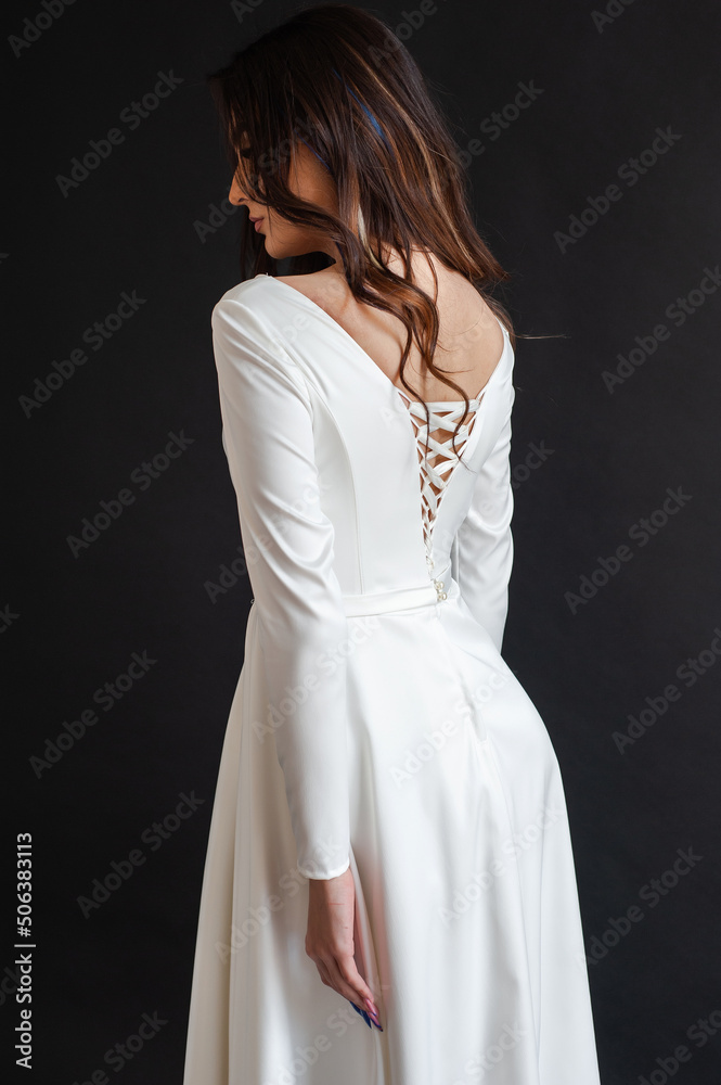 Charming young bride in luxurious wedding dress. Pretty girl in white. Emotions of happiness, laughter and smile, gray background Charming young bride in luxurious wedding dress. Pretty girl in white. Emotions of happiness, laughter and smile, gray background