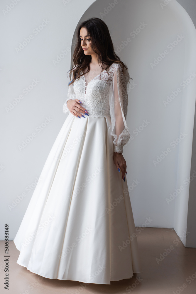 The beautiful woman posing in a wedding dress The beautiful woman posing in a wedding dress