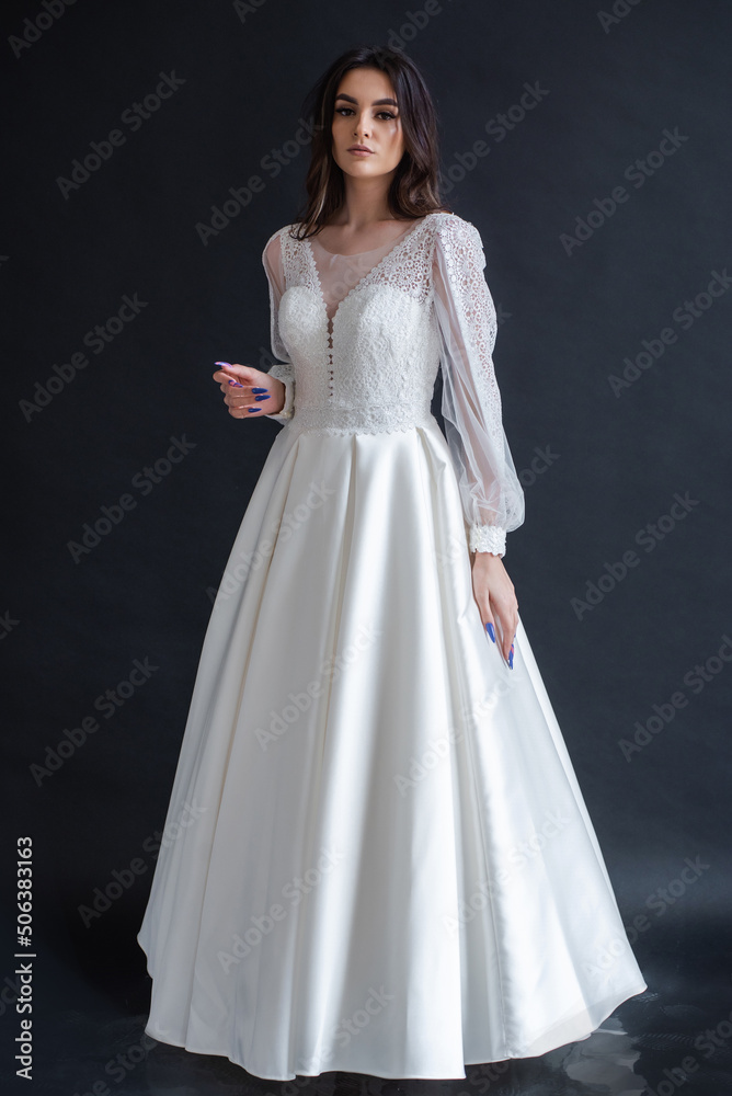The beautiful woman posing in a wedding dress The beautiful woman posing in a wedding dress