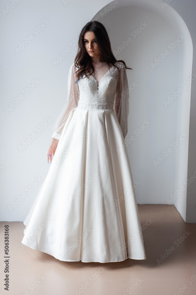The beautiful woman posing in a wedding dress The beautiful woman posing in a wedding dress