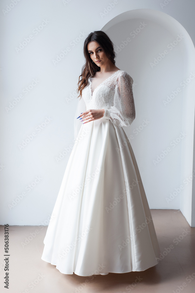 The beautiful woman posing in a wedding dress The beautiful woman posing in a wedding dress