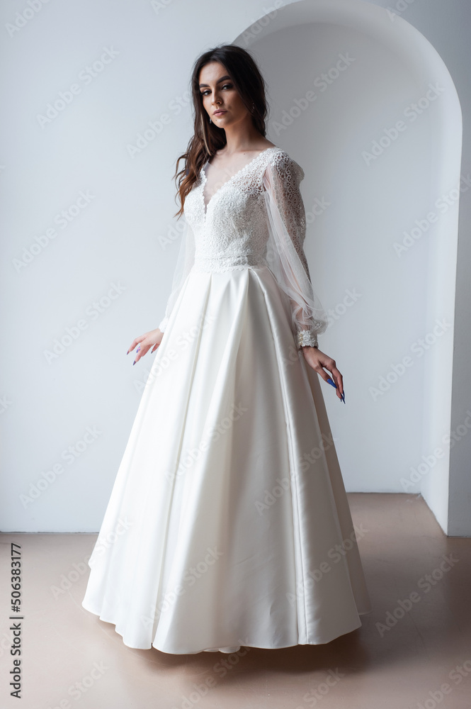 Beauty Portrait of bride wearing in wedding dress with voluminous skirt, studio photo. Young attractive bride. Smiling beautiful young bride