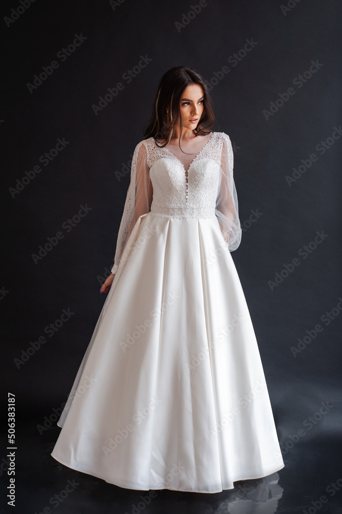 The beautiful woman posing in a wedding dress