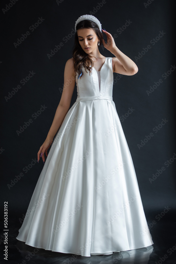 The beautiful woman posing in a wedding dress