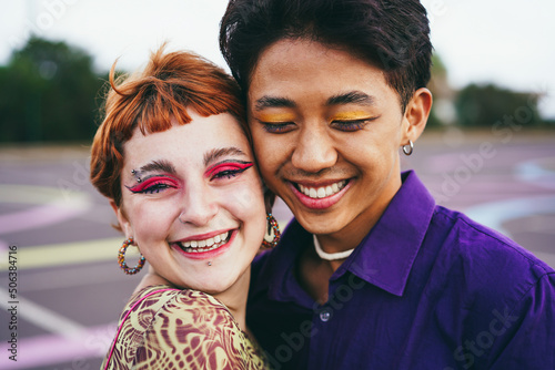 Young diverse friends having fun outdoor - Focus on gay asian guy wearing make-up photo
