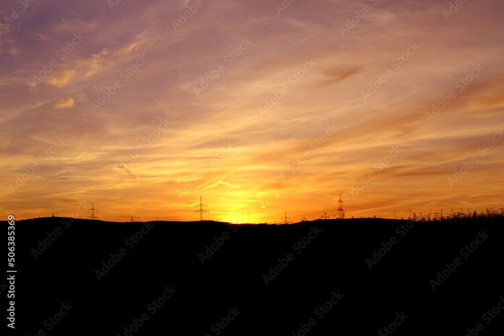 sunset in evening beautiful colorful dramatic sky with cloud, background light sky gradient with airplane trail lines, power towers, concept of heavenly space, meditative calmness and greatness