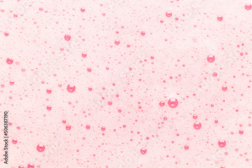 Pink bubbles on the surface of the water. Background for cosmetics, hygiene and washing.