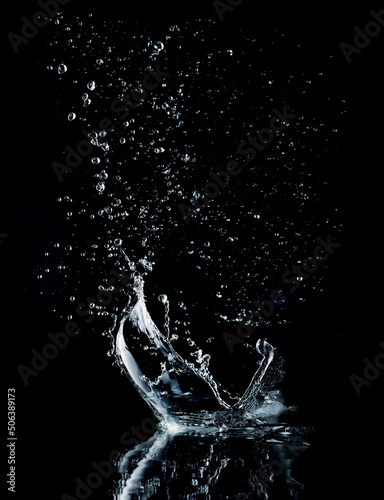 Water splash isolated on black background. Water crown splash. On black background. Side view.