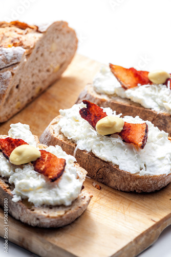 garlic spread on slice of bread served with bacon  grated cheese and mustard