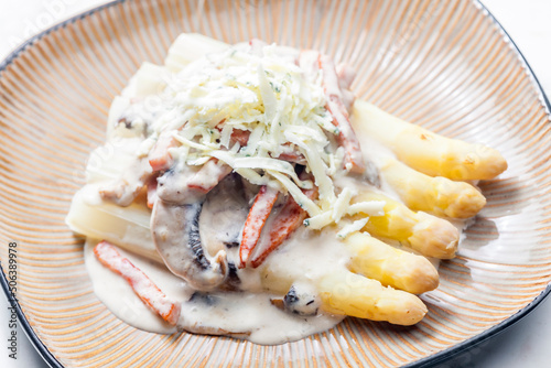 white aparagus with sauce of mushrooms and ham served with blue cheese photo