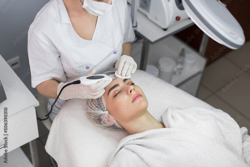 Skin Care. Close-up Of Beautiful Woman Receiving Ultrasound Cavitation Facial Peeling. Ultrasonic Skin Cleansing Procedure. Beauty Treatment. Cosmetology. Beauty Spa Salon. Skin Care. Close-up Of Beautiful Woman Receiving Ultrasound Cavitation Facial Peeling. Ultrasonic Skin Cleansing Procedure. Beauty Treatment. Cosmetology. Beauty Spa Salon.