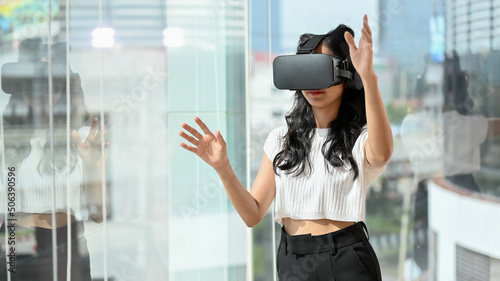 Foto Woman wearing a VR headset, playing a virtual reality digital game