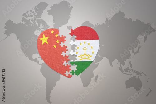 puzzle heart with the national flag of china and tajikistan on a world map background. Concept.
