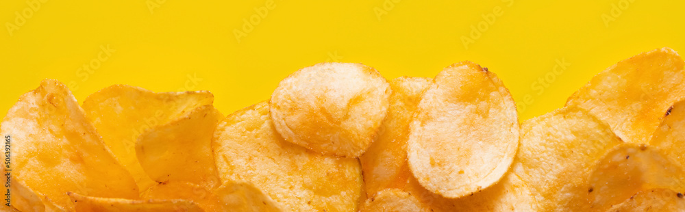 top view of delicious, crunchy and salty potato chips on yellow, banner - obrazy, fototapety, plakaty 