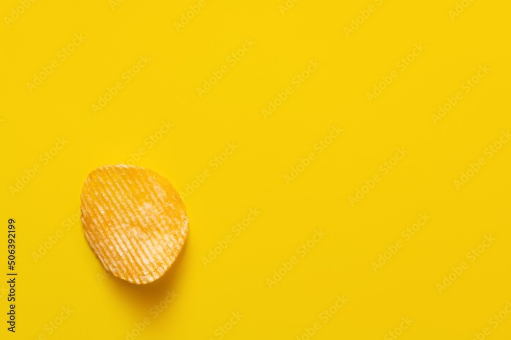 top view of single wavy and salty potato chip on yellow - obrazy, fototapety, plakaty 