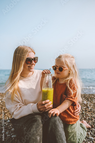 Photo Mother and child drinking smoothie  outdoor summer vacations family on beach tra