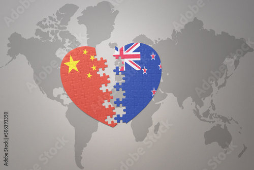 puzzle heart with the national flag of china and new zealand on a world map background. Concept.