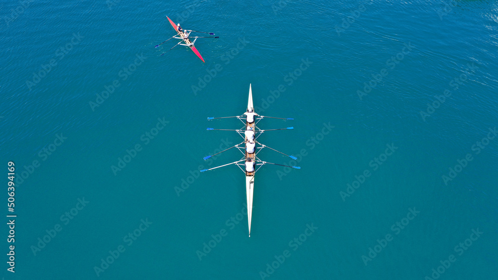 Fototapeta premium Aerial drone top down photo of sport canoe operated by team of young women in emerald sea waters