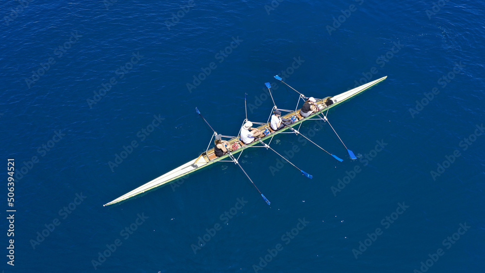 Naklejka premium Aerial drone photo of sport canoe operated by team of young trained athletes in deep blue Aegean sea