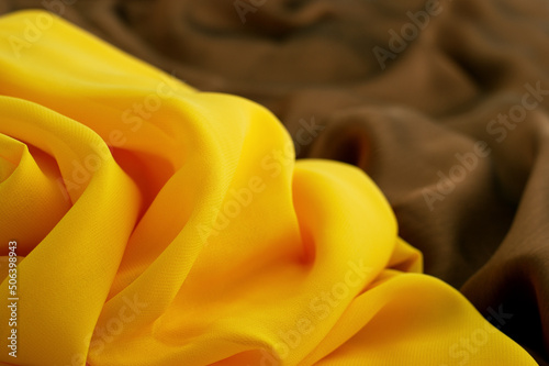 Silk fabric close up. Texture background in yellow and brown fabric. Textile in the form of silk fabric.