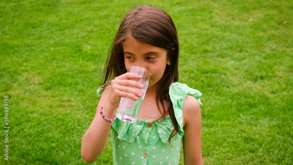 The child drinks water from a glass. Selective focus. The child drinks water from a glass. Selective focus.