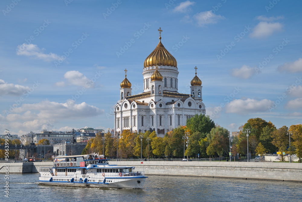 Moscow, Russia - September 29: View of the Cathedral of Christ the Savior and a pleasure boat sailing along the Moscow River on an autumn sunny day