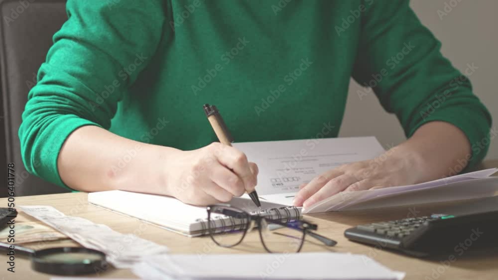 unrecognizable female hands writing budget numbers notes after home ...