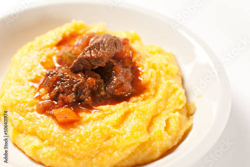 Polenta and beef stew on a plate. High quality photo.