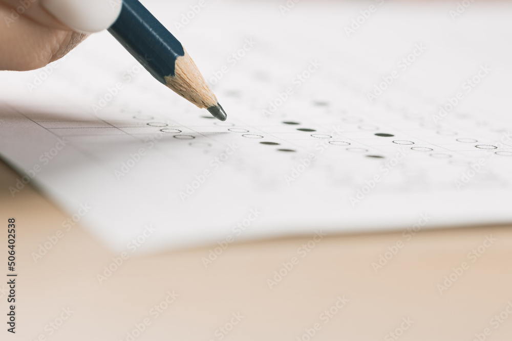 student hand testing in exercise and passing exam carbon paper computer sheet with pencil in school test room, education concept student hand testing in exercise and passing exam carbon paper computer sheet with pencil in school test room, education concept