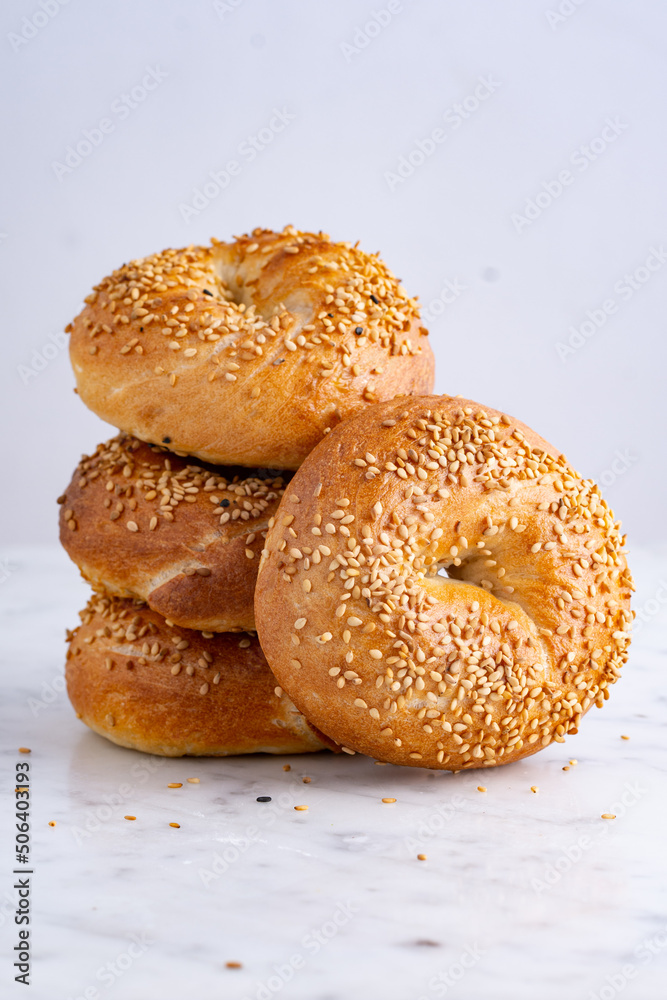 Stack of soft bagels topped with sesame seeds on white background Stack of soft bagels topped with sesame seeds on white background