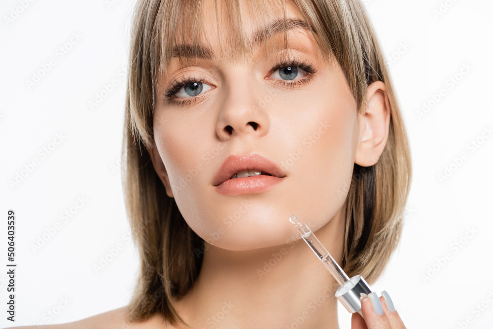young woman with bangs applying serum isolated on white young woman with bangs applying serum isolated on white