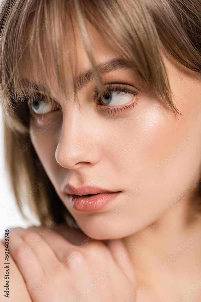 close up of young woman touching bare shoulder and looking away isolated on white close up of young woman touching bare shoulder and looking away isolated on white