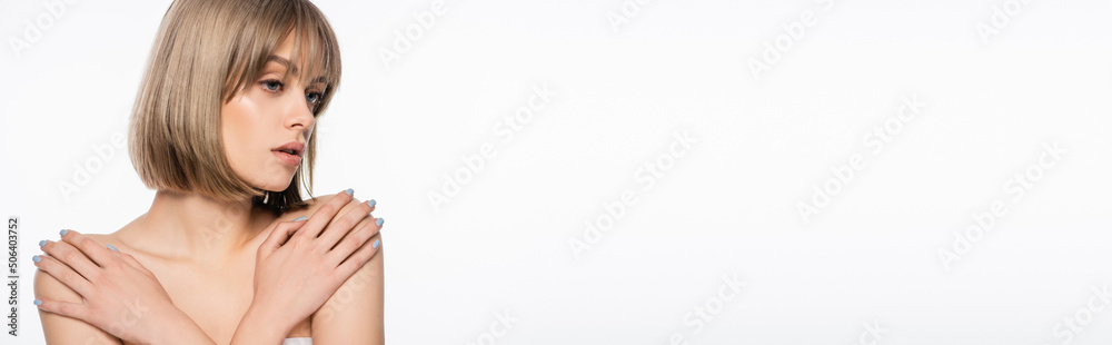 Fototapeta premium young woman touching bare shoulders and looking away isolated on white, banner