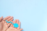 Top view of male hand holding sperm cutout in blue background. Men's health, sperm donation and care concept. 