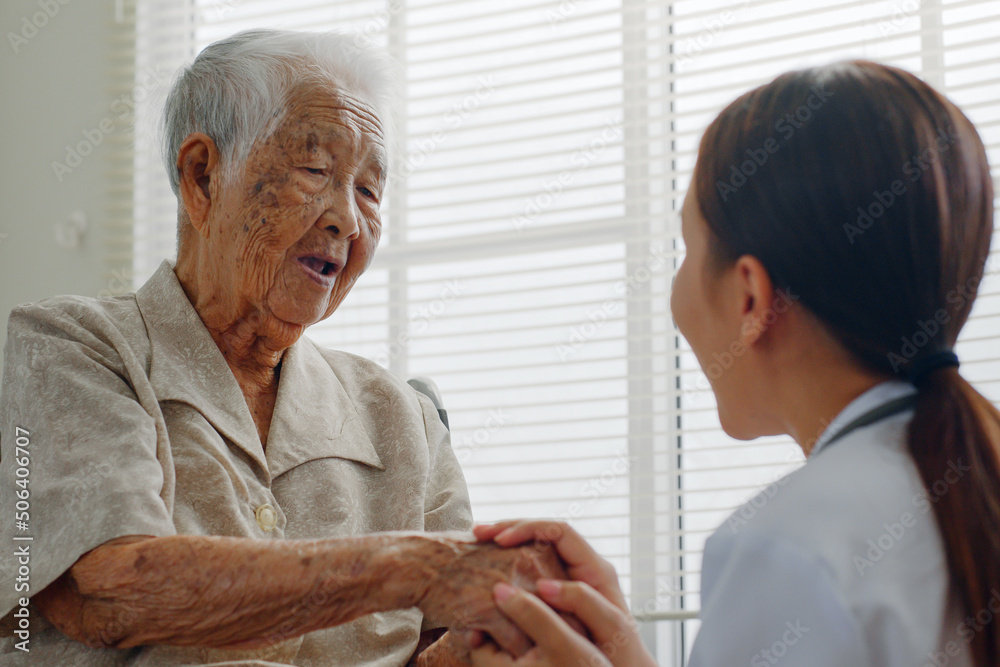 Fototapeta premium Asian doctor holding senior patient hand for encouragement and empathy, medical trust and support concept