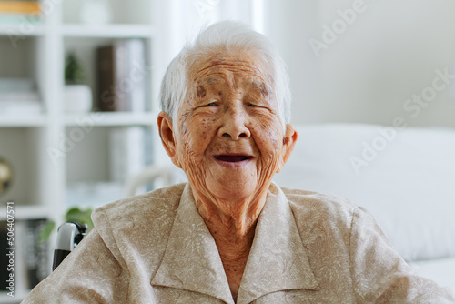 Portrait happy Asian senior woman 90s look at camera, smile and laugh at nursing home