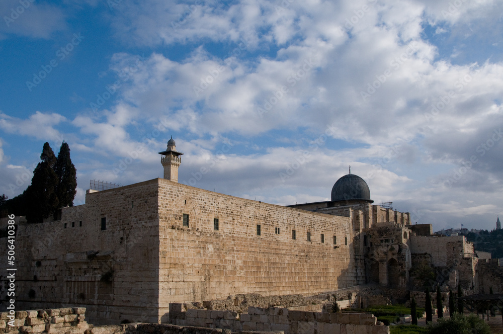 The western and southern walls of the Temple Mount in Jerusalem with a view of the black-domed Al Aqsa mosque and minaret.