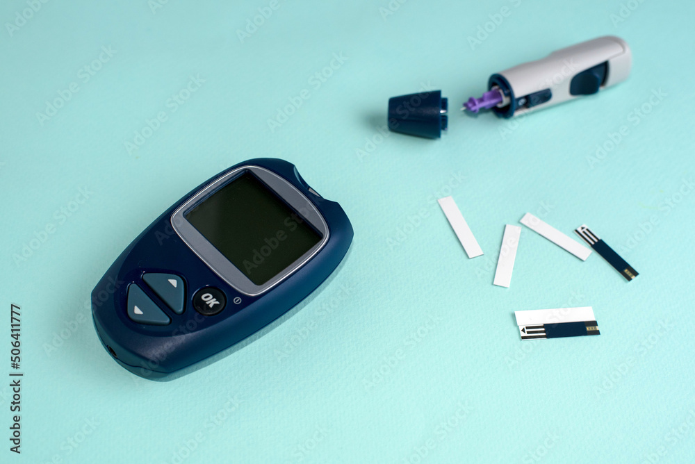 Glucose meter for diabetes tester using as Medicine, glycemia, healthcare and medical concept. Blue background. Glucose meter for diabetes tester using as Medicine, glycemia, healthcare and medical concept. Blue background.