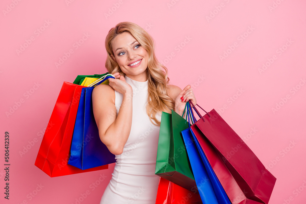 Photo of gorgeous nice lady hold packages look empty space isolated on pink color background Photo of gorgeous nice lady hold packages look empty space isolated on pink color background