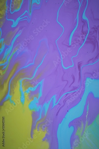 Marble yellow-blue-lilac background. Acrylic paint mixes freely and creates an interesting pattern. Bright saturated colors. Background for the cover of a laptop, notebook.