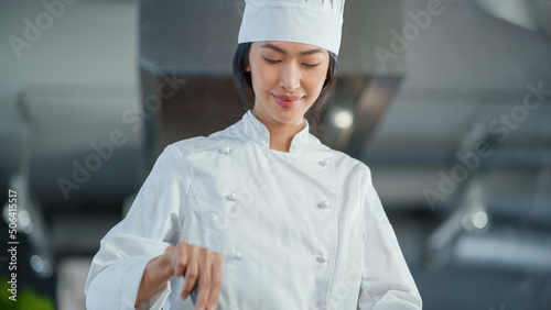 Restaurant Kitchen: Portrait of Asian Female Chef Stirs Her Favourite most Flavourful Dish, Smiles. Professional Cooking Delicious and Traditional Authentic Food. Healthy Dish Preparation. Low Angle