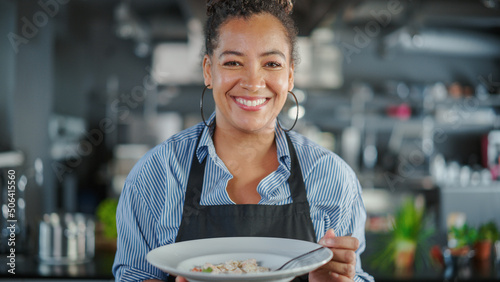 Fotografi Restaurant Kitchen: Portrait of Black Female Chef Prepares Dish, Tasting Food, Enjoying it