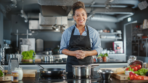 TV Cooking Show in Restaurant Kitchen: Portrait of Black Female Chef Talks, Teaches How to Cook Food. Online Courses, Streaming Service, Learning Video Lectures. Healthy Dish Recipe Preparation photo
